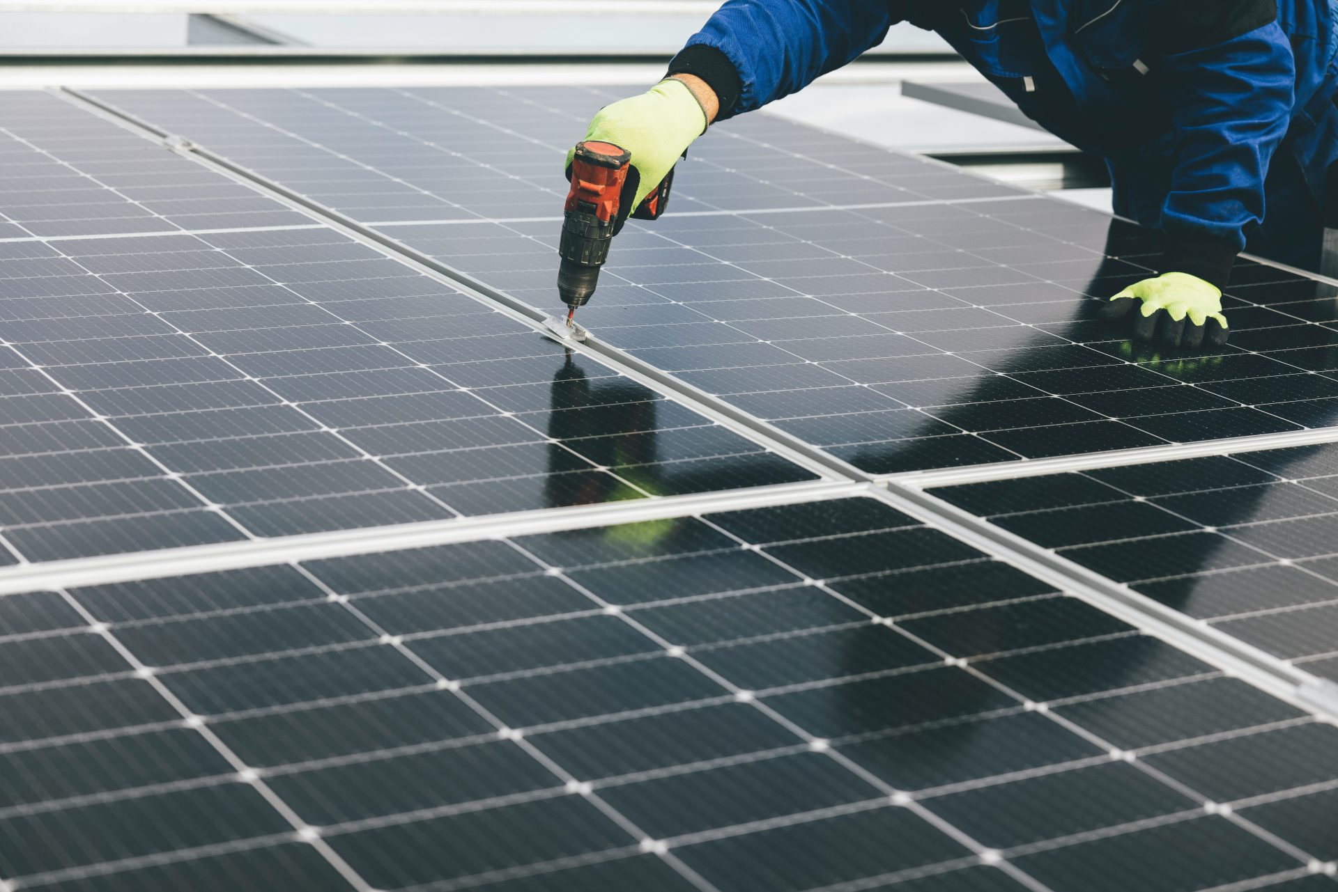 Worker installing solar panels on rooftop.