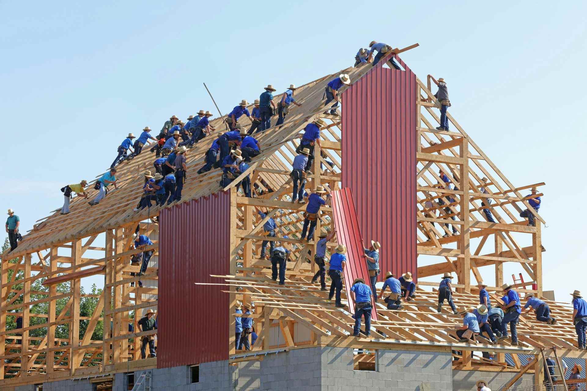 Team assembling wooden roof structure together